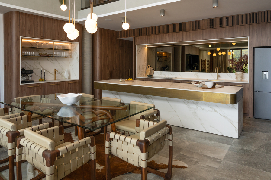 a luxury kitchen with a marble island and walnut cabinetry.
